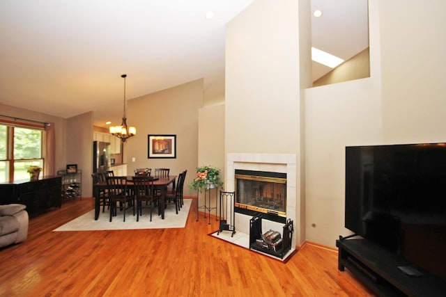 135 Miller Rd, Lake Zurich, IL 60047 - dining room featuring wood finished floors, a chandelier, high vaulted ceiling, a tile fireplace, and recessed lighting