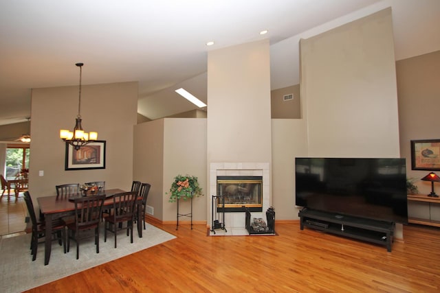 135 Miller Rd, Lake Zurich, IL 60047 - dining space featuring wood finished floors, a chandelier, high vaulted ceiling, a fireplace, and recessed lighting