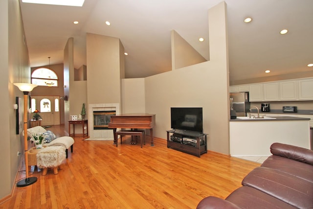 135 Miller Rd, Lake Zurich, IL 60047 - living room featuring a tile fireplace, light wood-style flooring, high vaulted ceiling, and recessed lighting
