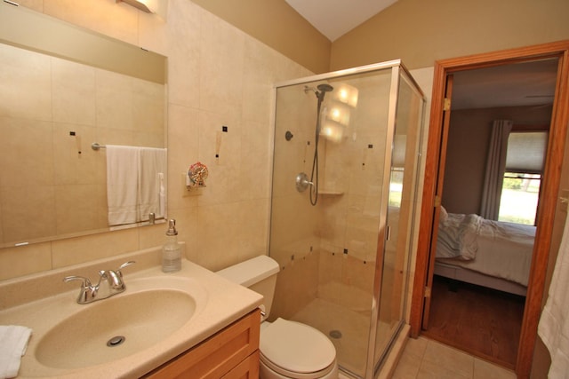 135 Miller Rd, Lake Zurich, IL 60047 - ensuite bathroom featuring a stall shower, tile walls, vanity, vaulted ceiling, and tile patterned floors