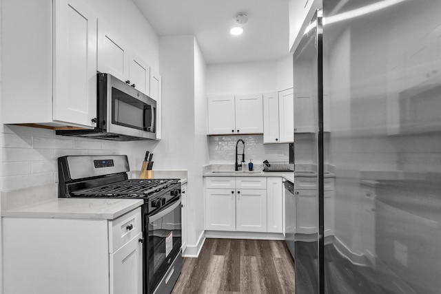 5335 N California Ave Unit 103, Chicago, IL 60625 - kitchen with stainless steel appliances, dark wood-style flooring, decorative backsplash, white cabinets, and recessed lighting
