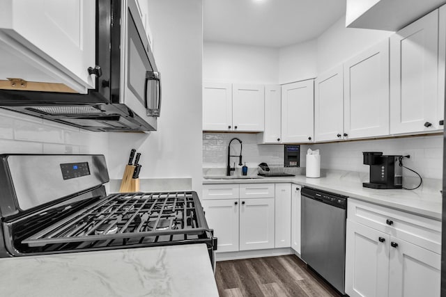 5335 N California Ave Unit 103, Chicago, IL 60625 - kitchen with stainless steel appliances, white cabinetry, decorative backsplash, and dark wood finished floors