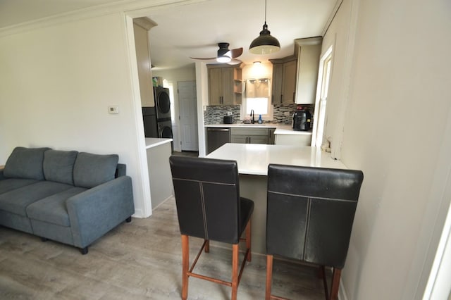 1509 Morris Ave, Berkeley, IL 60163 - kitchen featuring stacked washer / drying machine, stainless steel dishwasher, a peninsula, decorative backsplash, and light countertops