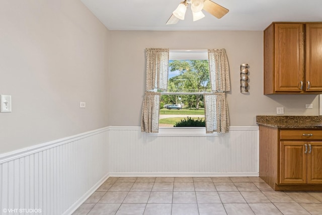 1902 N Washington St, Wheaton, IL 60187 - kitchen featuring plenty of natural light, a wainscoted wall, brown cabinets, ceiling fan, and light tile patterned flooring