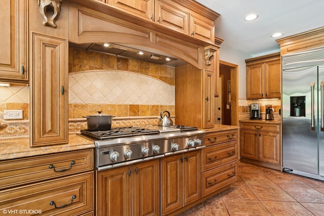 10305 Ridge Ln, Huntley, IL 60142 - kitchen featuring stainless steel appliances, decorative backsplash, light stone counters, tile patterned flooring, and brown cabinets
