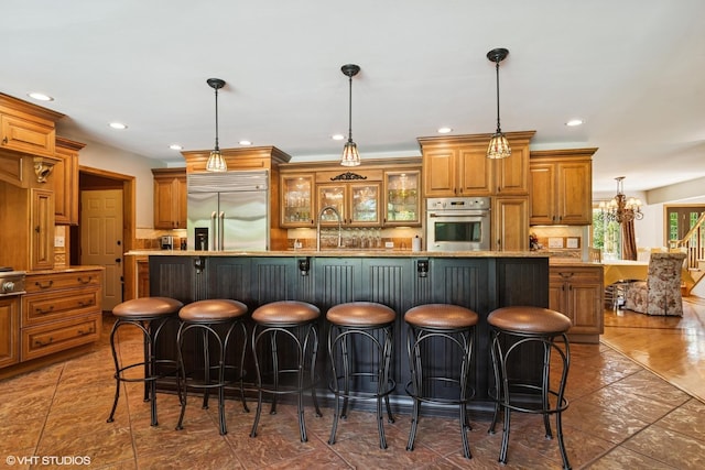 10305 Ridge Ln, Huntley, IL 60142 - kitchen featuring stainless steel appliances, decorative backsplash, brown cabinets, a kitchen breakfast bar, and recessed lighting