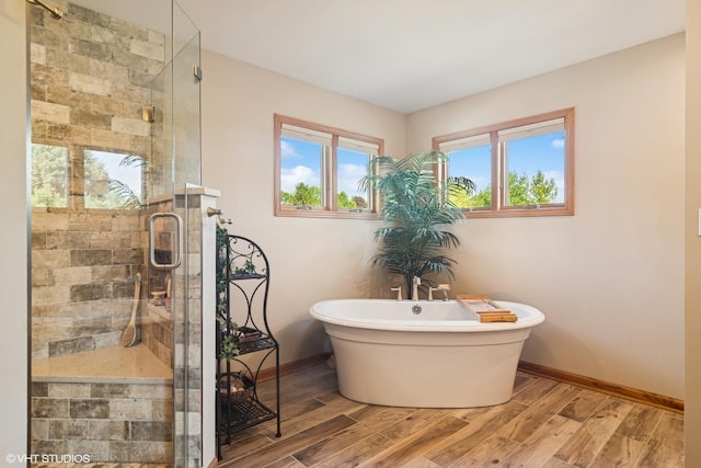 10305 Ridge Ln, Huntley, IL 60142 - bathroom with a stall shower, a freestanding bath, and wood finished floors