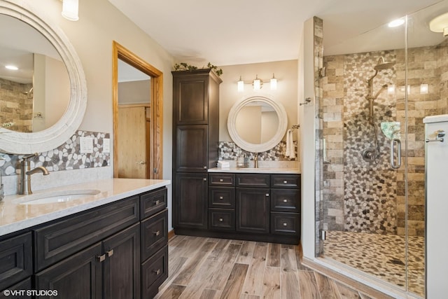 10305 Ridge Ln, Huntley, IL 60142 - bathroom with a shower stall, two vanities, decorative backsplash, and wood finished floors