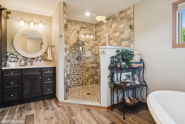 10305 Ridge Ln, Huntley, IL 60142 - full bath featuring a stall shower, a freestanding bath, vanity, decorative backsplash, and wood finished floors