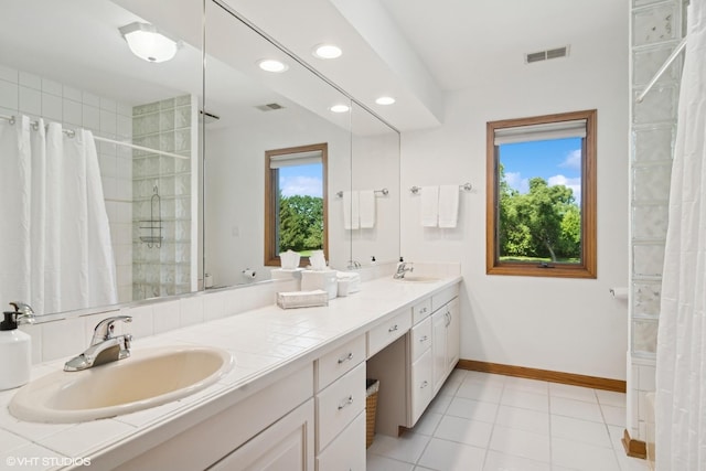 10305 Ridge Ln, Huntley, IL 60142 - bathroom featuring double vanity, recessed lighting, tiled shower, and tile patterned floors