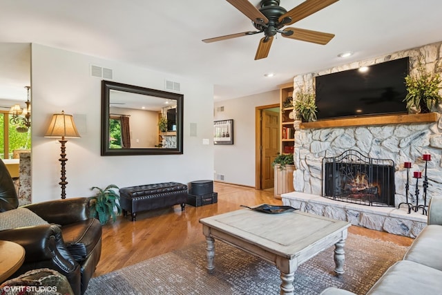 10305 Ridge Ln, Huntley, IL 60142 - living area featuring wood finished floors, a ceiling fan, a fireplace, and a chandelier