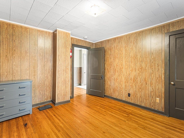 2242 S 5th St, Rockford, IL 61104 - unfurnished bedroom with wood finished floors, wood walls, and crown molding