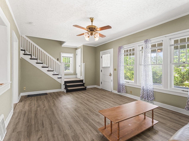 2242 S 5th St, Rockford, IL 61104 - living area featuring a textured ceiling, stairway, healthy amount of natural light, wood finished floors, and ornamental molding