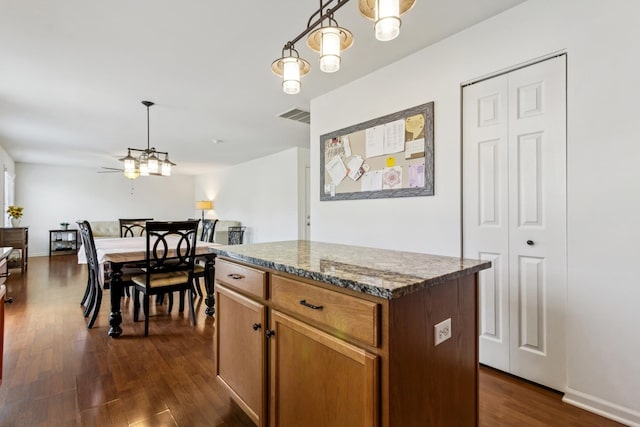 774 Dover St, Pingree Grove, IL 60140 - kitchen featuring dark wood finished floors, a kitchen island, hanging light fixtures, brown cabinets, and open floor plan