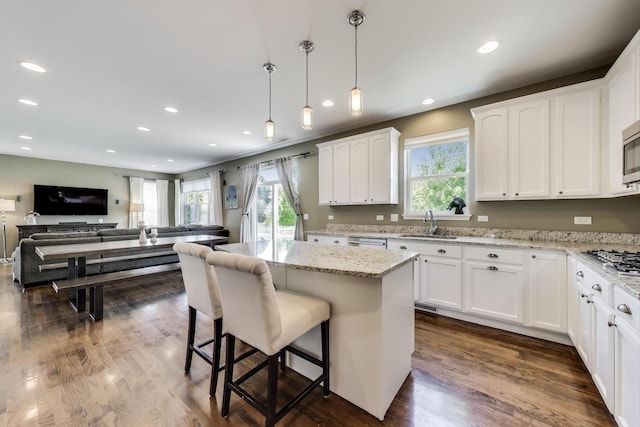 2301 Bluewater Dr, Wauconda, IL 60084 - kitchen with a breakfast bar area, white cabinetry, light stone countertops, open floor plan, and recessed lighting