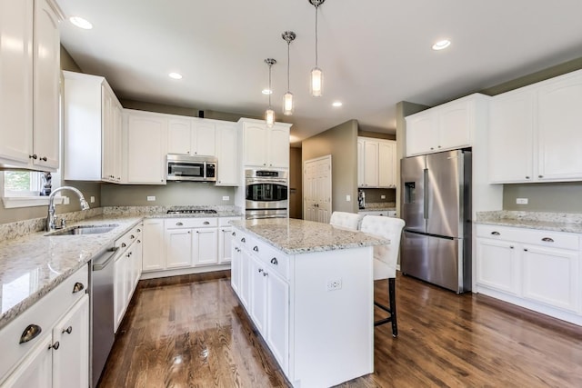 2301 Bluewater Dr, Wauconda, IL 60084 - kitchen featuring appliances with stainless steel finishes, dark wood-style flooring, white cabinets, a kitchen island, and recessed lighting