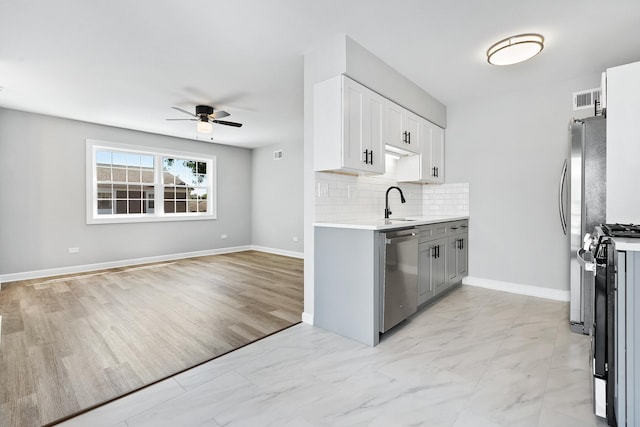676 Cleo Ct Unit 676, Wheeling, IL 60090 - kitchen with appliances with stainless steel finishes, a ceiling fan, light countertops, backsplash, and light marble finish flooring