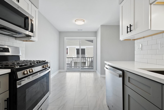 676 Cleo Ct Unit 676, Wheeling, IL 60090 - kitchen with stainless steel appliances, light marble finish flooring, gray cabinetry, light countertops, and tasteful backsplash