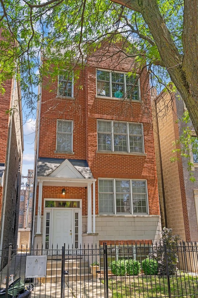 3251 N Racine Ave Unit 3, Chicago, IL 60657 - view of front of home featuring a fenced front yard, brick siding, and a gate