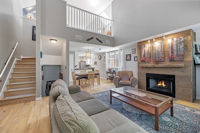 3251 N Racine Ave Unit 3, Chicago, IL 60657 - living area with wood finished floors, a warm lit fireplace, stairs, and a towering ceiling