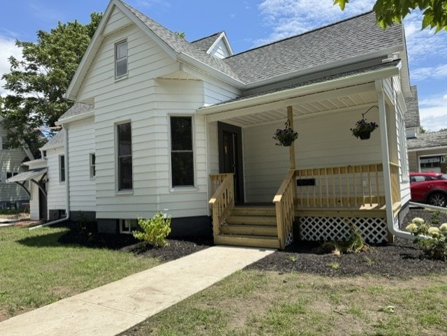 207 W Graham St, Bloomington, IL 61701 - view of front of home with a shingled roof, covered porch, and a front lawn
