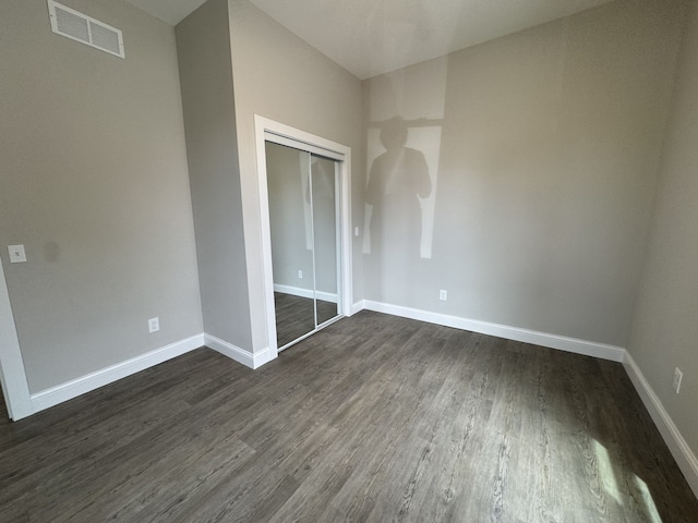 207 W Graham St, Bloomington, IL 61701 - unfurnished bedroom featuring dark wood-style floors and a closet