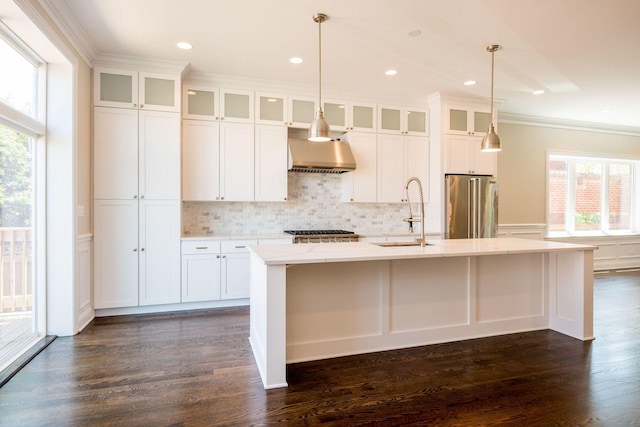 4141 N Dickinson Ave, Chicago, IL 60641 - kitchen featuring wall chimney exhaust hood, high end fridge, healthy amount of natural light, ornamental molding, and a kitchen island with sink