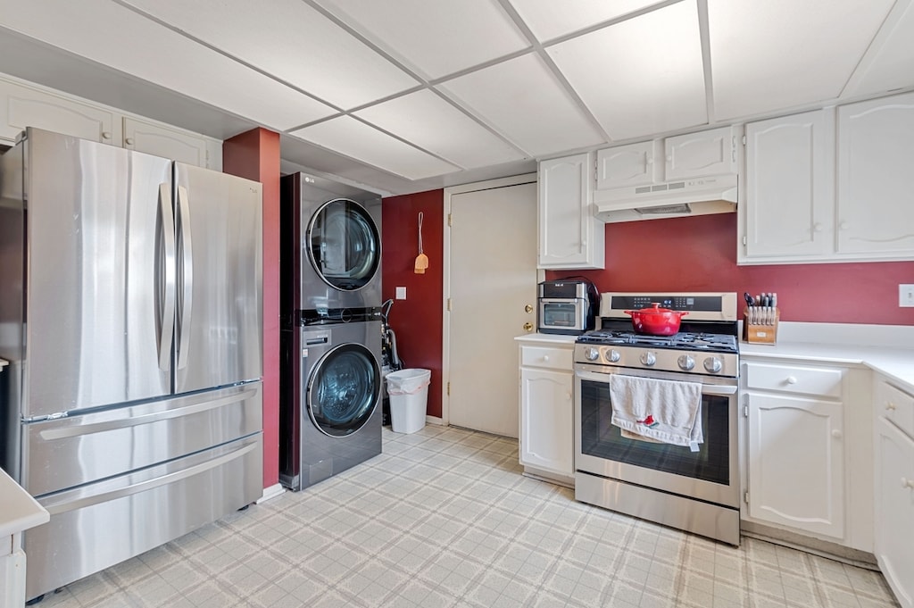 2658 Sumac St, Woodridge, IL 60517 - kitchen with stainless steel appliances, under cabinet range hood, stacked washer / drying machine, white cabinetry, and light countertops