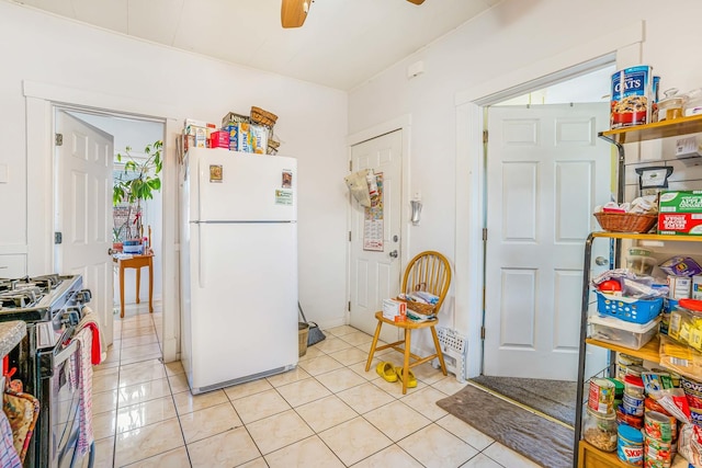 4438 N Moody Ave, Chicago, IL 60630 - kitchen with freestanding refrigerator, gas range, ceiling fan, and light tile patterned flooring