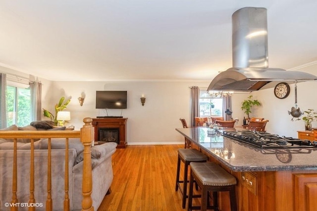 2S200 Valley Rd, Lombard, IL 60148 - kitchen with island exhaust hood, stainless steel gas cooktop, a breakfast bar area, brown cabinets, and light wood finished floors