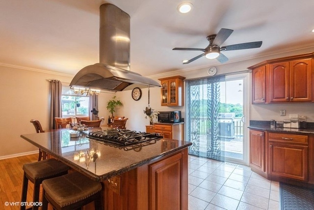 2S200 Valley Rd, Lombard, IL 60148 - kitchen with island exhaust hood, gas cooktop, a breakfast bar area, ornamental molding, and brown cabinetry