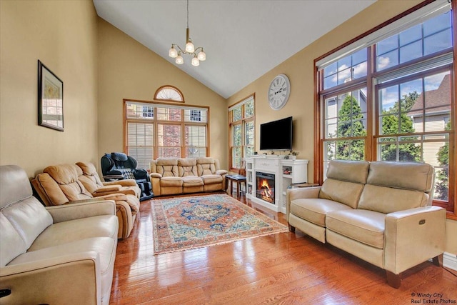 1505 Della Dr, Hoffman Estates, IL 60169 - living room featuring high vaulted ceiling, wood finished floors, a chandelier, and a glass covered fireplace