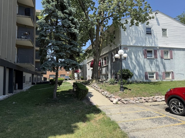 9513 Kelvin Ln Unit 2111, Schiller Park, IL 60176 - view of home's exterior with uncovered parking and a yard