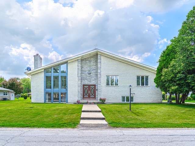 921 Cassie Dr, Joliet, IL 60435 - view of front of home with brick siding, a chimney, and a front yard