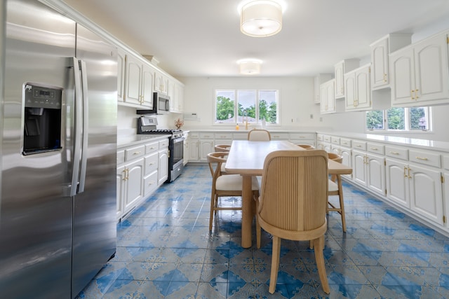 921 Cassie Dr, Joliet, IL 60435 - kitchen with appliances with stainless steel finishes, white cabinets, light countertops, and dark tile patterned floors