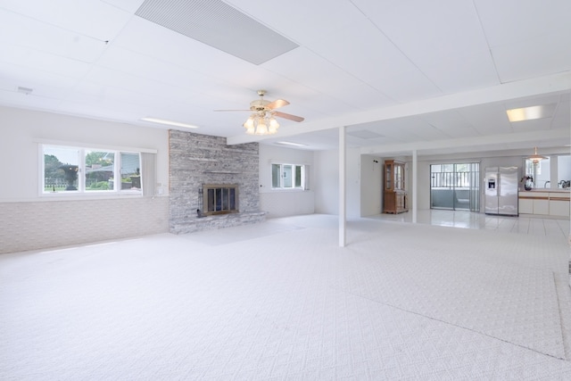 921 Cassie Dr, Joliet, IL 60435 - unfurnished living room featuring plenty of natural light, carpet, a stone fireplace, and a ceiling fan