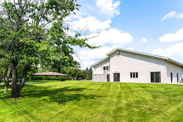 921 Cassie Dr, Joliet, IL 60435 - rear view of house featuring a lawn and brick siding