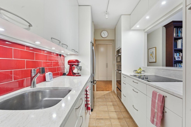 1325 N State Pkwy Unit 8E, Chicago, IL 60610 - kitchen featuring stainless steel appliances, white cabinets, light tile patterned flooring, backsplash, and light stone countertops