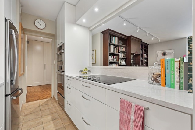 1325 N State Pkwy Unit 8E, Chicago, IL 60610 - kitchen with black electric stovetop, freestanding refrigerator, rail lighting, and white cabinets