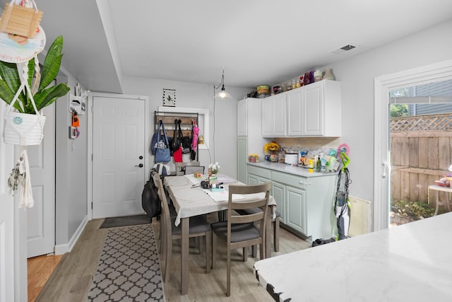 1100 Singleton Dr, Roselle, IL 60172 - kitchen with light countertops, light wood-type flooring, and white cabinets