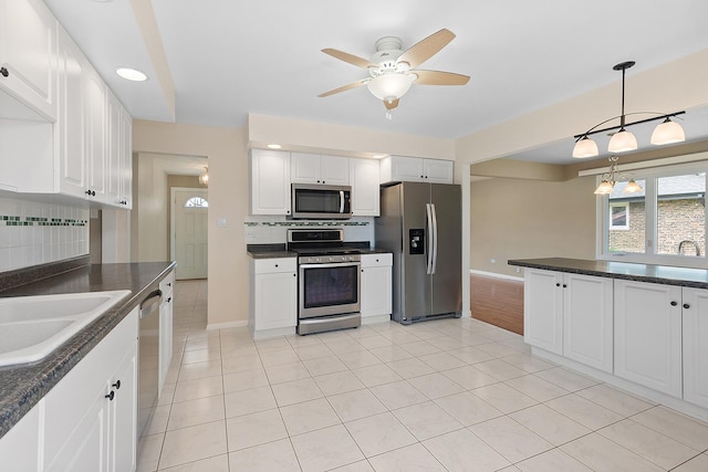 15363 Sunflower Ct, Orland Park, IL 60462 - kitchen with stainless steel appliances, dark countertops, decorative backsplash, ceiling fan, and light tile patterned flooring