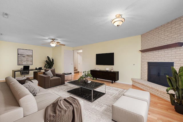 15363 Sunflower Ct, Orland Park, IL 60462 - living area featuring light wood finished floors, a ceiling fan, a brick fireplace, a textured ceiling, and stairway