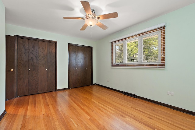 15363 Sunflower Ct, Orland Park, IL 60462 - unfurnished bedroom with two closets, light wood-type flooring, and a ceiling fan