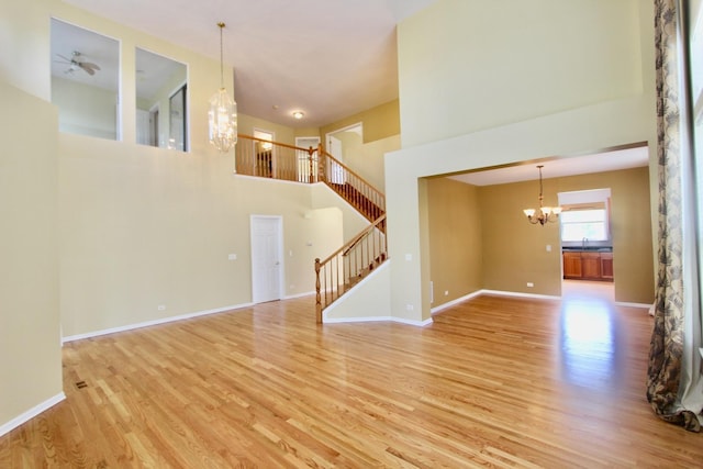 18737 W Ash Dr, Lake Villa, IL 60046 - unfurnished room featuring a chandelier, light wood-style flooring, stairway, and a towering ceiling