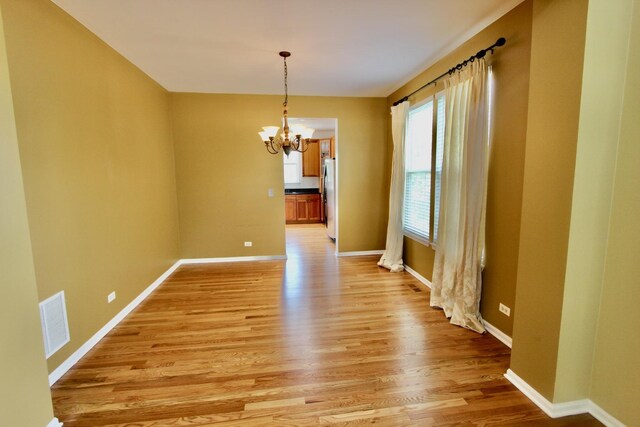 18737 W Ash Dr, Lake Villa, IL 60046 - unfurnished dining area with a chandelier and light wood finished floors