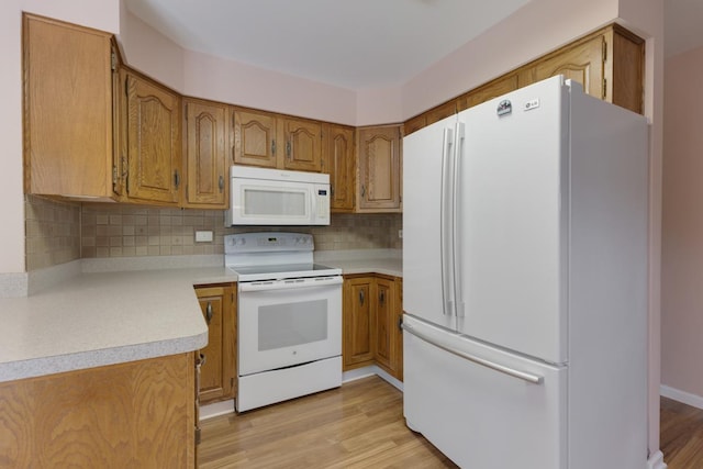 534 Grosvener Ln, Elk Grove Village, IL 60007 - kitchen with white appliances, backsplash, brown cabinetry, light wood finished floors, and light countertops