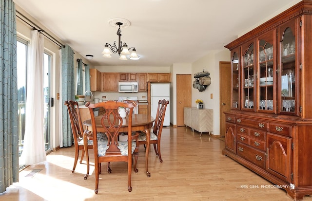 2227 N Quaker Hollow Ln, Round Lake Beach, IL 60073 - dining room with a chandelier and light wood-style flooring