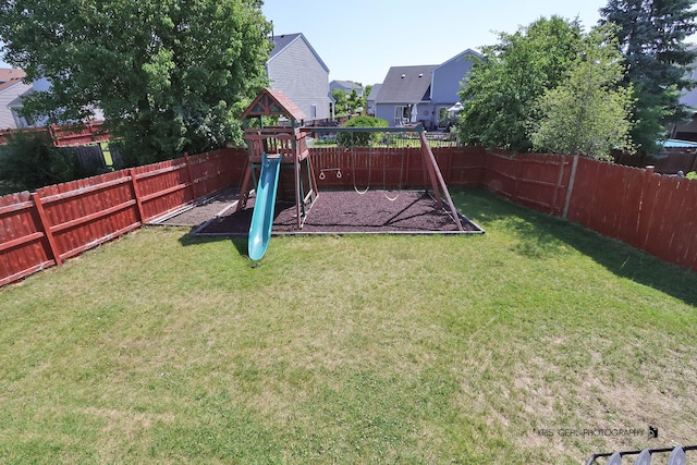 2227 N Quaker Hollow Ln, Round Lake Beach, IL 60073 - fenced backyard with a playground and a residential view
