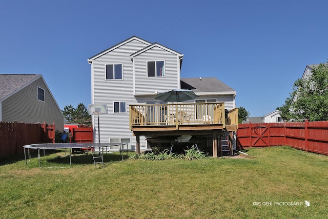 2227 N Quaker Hollow Ln, Round Lake Beach, IL 60073 - rear view of property with a trampoline, a wooden deck, and a fenced backyard