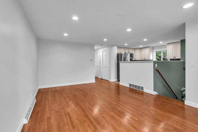 1549 Revere Cir, Schaumburg, IL 60193 - unfurnished living room with recessed lighting, a baseboard radiator, and light wood-type flooring